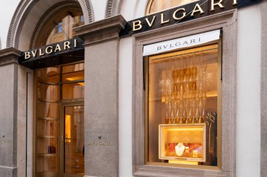 Milan, İtalya - Nisan 08, 2025: Lüks mücevher sergisi olan Bvlgari butik mağazası. Zarif taş cephe, altın iç ışıklar ve Milan 'da damgalanmış tabela..
