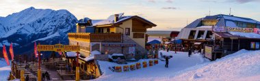 Piani di Bobbio, İtalya - 24.12.2022: Dağ restoranı ve kayakçıların panoramik manzarası. Karla kaplı tepeler, rahat yemek alanları ve kayak merkezi aktiviteleri. İtalya, Lecco yakınlarındaki dağ alp kayak merkezi.
