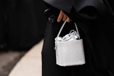 Milan, İtalya - 25 Mart 2024: Kadın parlak metalik el çantası takıyor. Moda kıyafetleri, sokak tarzı.