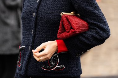Milan, İtalya - 25 Mart 2024: Kadın kırmızı el çantası takıyor. Moda kıyafetleri, sokak tarzı.