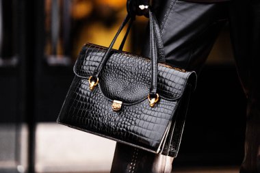 Milan, İtalya - 25 Mart 2024: kadın siyah timsah derisi çanta giyiyor. Moda kıyafetleri, sokak tarzı.