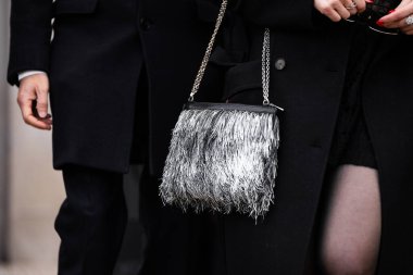 Milan, İtalya - 25 Mart 2024: Kadın gümüş püsküllü çanta takıyor. Moda kıyafetleri, sokak tarzı.