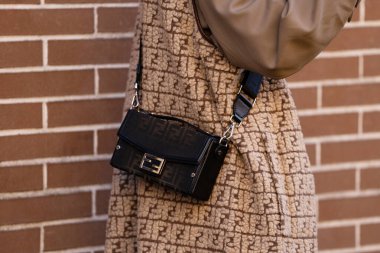 Milan, İtalya - 13 Ocak, 2024: Adam Fendi Baguette marka bagaj çantası giyiyor, sokak tarzı detaylar, moda kıyafeti ayrıntıları