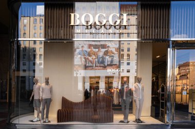 Milan, İtalya - Nisan 08, 2025: Boggi Milano modern erkek giyim sergisi ve mankenleri olan bir mağaza. Milano 'daki moda mağazasında marka işareti ve yansıması var..