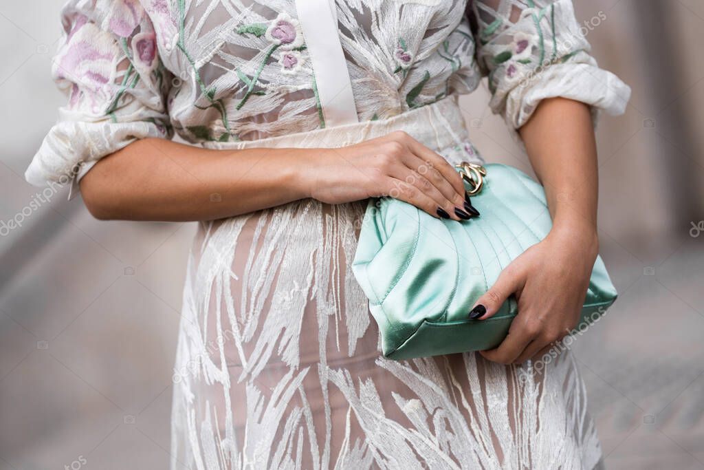 Milan, Italy - March, 25, 2024: Woman wears mint clutch. Fashion outfit detail, street style