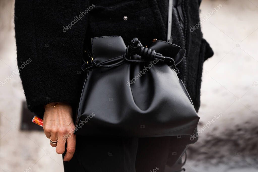 Milan, Italy - March, 25, 2024: Woman wears black leather handbag. Fashion outfit detail, street style
