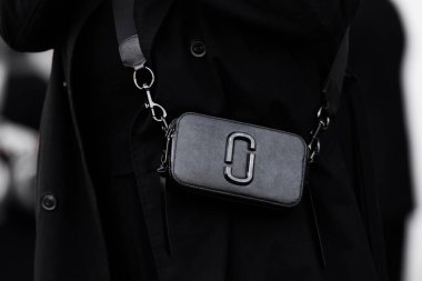 Milan, İtalya - 25 Mart 2024: Kadın Marc Jacobs 'un zarif siyah DTM çantasını takıyor. Moda kıyafetleri, sokak tarzı.