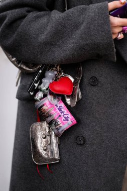 Milan, İtalya - 28 Mart 2024: Kadın, Pochette Balenciaga ve Balenciaga Le Cagole marka mini cüzdan takıyor. Moda kadını kıyafet ayrıntıları, sokak tarzı.