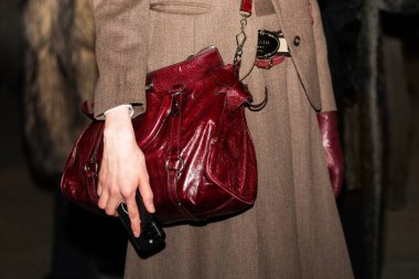 Milan, İtalya - 25 Mart 2024: Kadın kırmızı deri Miu Miu marka üst kol çantası giyiyor. Moda kadını kıyafet ayrıntıları, sokak tarzı.