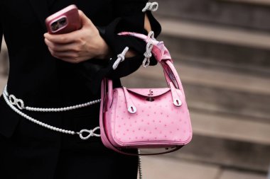 Milan, İtalya - 25 Mart 2024: Kadın Hermes pembe çanta giyiyor. Moda kıyafetleri, sokak tarzı.