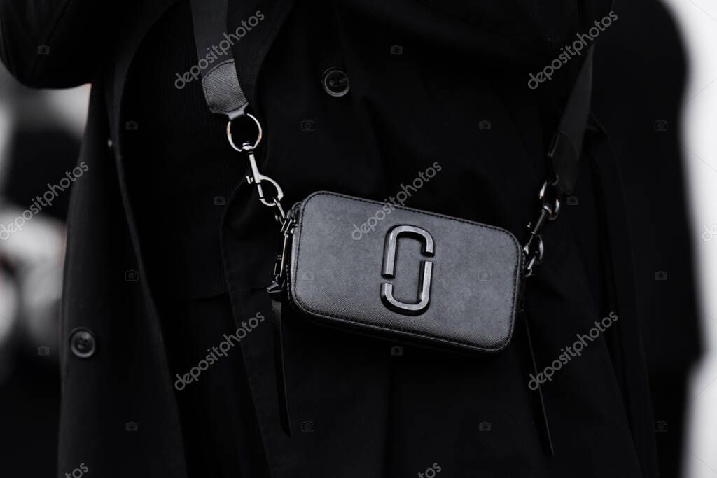 Milan, Italy - March, 25, 2024: Woman wears Marc Jacobs The Snapshot DTM elegant black handbag. Fashion outfit detail, street style