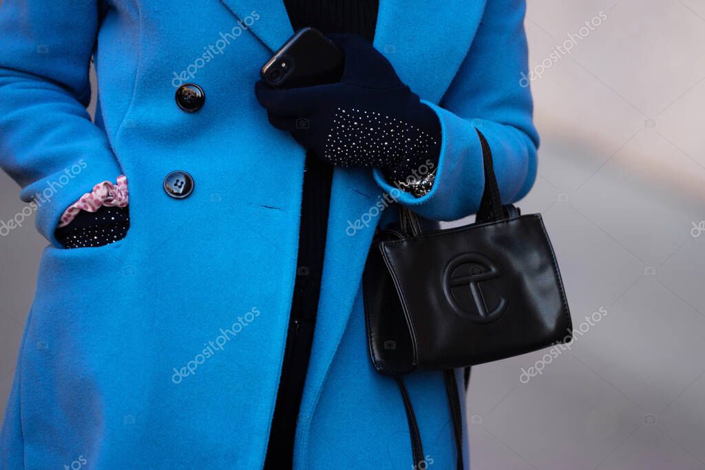 Milan, Italy - January, 13, 2024: Woman wears Telfar small shopping bag. Fashion outfit detail, street style