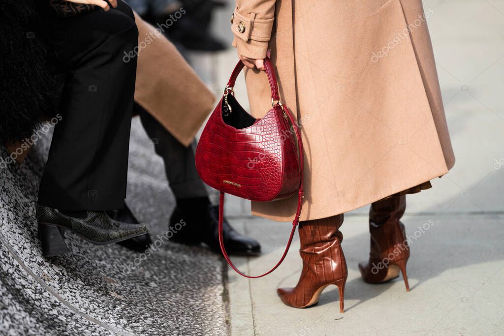 Florence, Italy - January, 10, 2024: Woman wears Emporio Armani Croc Hobo red handbag. Fashion outfit detail, street style