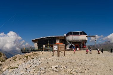 Passo Tonale, İtalya - 10.08.2024: Ziyaretçili dağ teleferiği istasyonu, açık hava macerası.