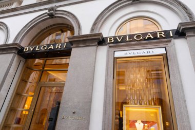 Milan, İtalya - Nisan 08, 2025: Lüks mücevher sergisi olan Bvlgari butik mağazası. Zarif taş cephe, altın iç ışıklar ve Milan 'da damgalanmış tabela..