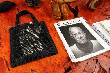 Milan, İtalya - Nisan 08, 2025: Chloe siyah örgü çantalı, takunyalı ve desenli kırmızı masa üzerindeki moda kitapları. Butik perakende satış bölümü, Milan galerisi..