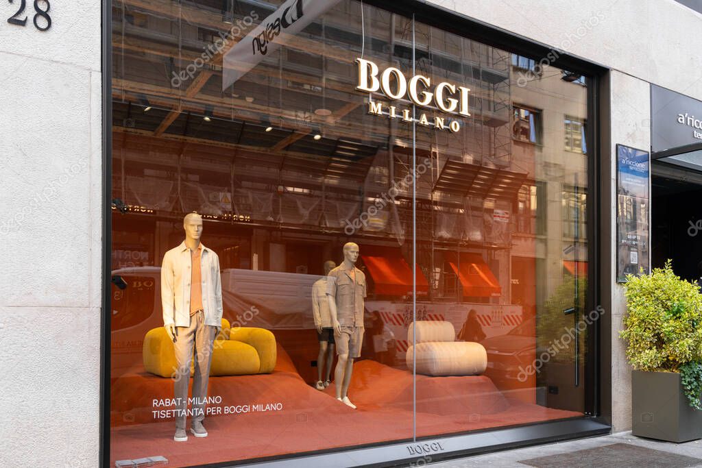 Milan, Italy - April, 08, 2025: Boggi Milano storefront window display with male mannequins in beige outfits. Italian fashion brand in city retail zone.