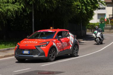 Lecco, İtalya - 29.05.2025: Bisiklet yarışı sırasında Giro dItalia destek aracı ve motosiklet sokakta. Giro dItalia, her yıl düzenlenen çok aşamalı bisiklet yarışı.