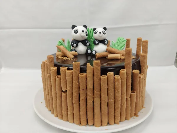 Birthday cake with panda bear and wafer rolls on white background panda and bamboo