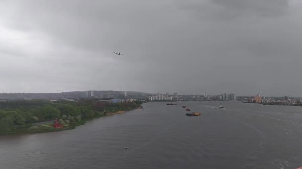 片側の曇った空の緑の森と 他側の混雑した街 ロンドン からの眺めを水上に船を着陸するためのフライト — ストック動画