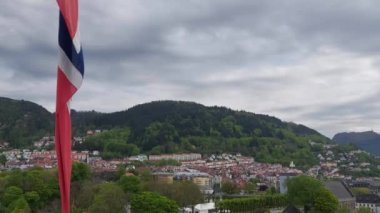 Bergen 'in büyüleyici mimarisi, yuvarlanan tepeleri ve huzurlu manzarası. Norveç bayrağı dalgalanıyor 