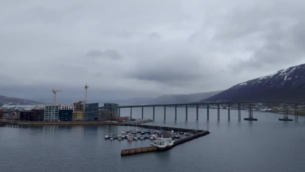 트롬소 다리는 건축물로 둘러싸인 조용한 바다에서 반영됩니다 — 비디오