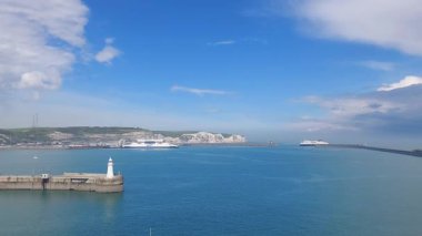 Birleşik Krallık Dover 5 Nisan 2024 güneşli bir günde arka planda ikonik beyaz uçurumlar bulunan Dover limanının nefes kesici manzarası. Liman hareketli, dinamik ama dinamik bir deniz manzarasını vurguluyor..