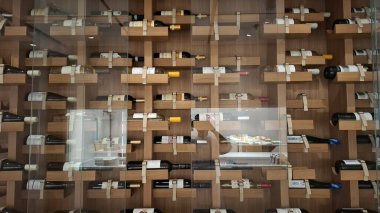 Norveç Bergan 1 / 20 / 2025 Duvara monte edilmiş ahşap şarap rafı çeşitli şarap şişelerini düzenli bir şekilde sergiliyor, zarafet ve işlevselliği yansıtıyor. Arkaplan, gelişmiş bir iç ayarın altını çiziyor.