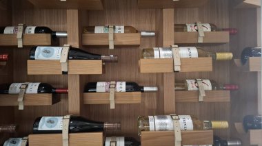 Norveç Bergan 1 / 20 / 2025 Duvara monte edilmiş ahşap şarap rafı çeşitli şarap şişelerini düzenli bir şekilde sergiliyor, zarafet ve işlevselliği yansıtıyor. Arkaplan, gelişmiş bir iç ayarın altını çiziyor.