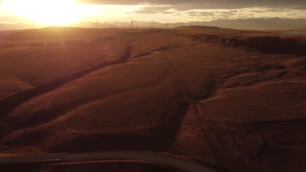 加拿大艾伯塔省平彻溪附近 空中落日风车在遥远的山顶上 阳光普照 俯瞰遥远的落基山脉 — 图库视频影像