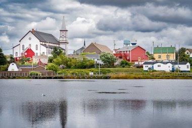 Bonavista Newfoundland Kanada, 22 Eylül 2022: Tarihi Kilise ve su kuleleri Eski Körfez Havuzu 'ndaki su yansıtmalı küçük doğu kıyısındaki evlere bakıyor.