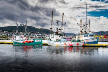 Bonavista Newfoundland Kanada, 22 Eylül 2022: Doğu kıyısındaki evlere bakan balıkçı tekneleri dramatik bir gökyüzü altında.