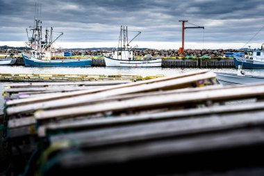 Whiteway Newfoundland Kanada, 25 Eylül 2022: Tahta istiridye tuzakları Kanada doğu kıyısı boyunca balıkçı tekneleriyle dolu bir marinaya bakıyor..