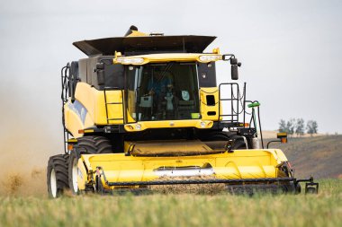 Rocky View County Alberta Canada, 14 Nisan 2023: Çiftçi Kuzey Amerika bozkırlarındaki bir arpa tarlasında hasat bataklıkları oluştururken New Holland 'ı işletiyor..