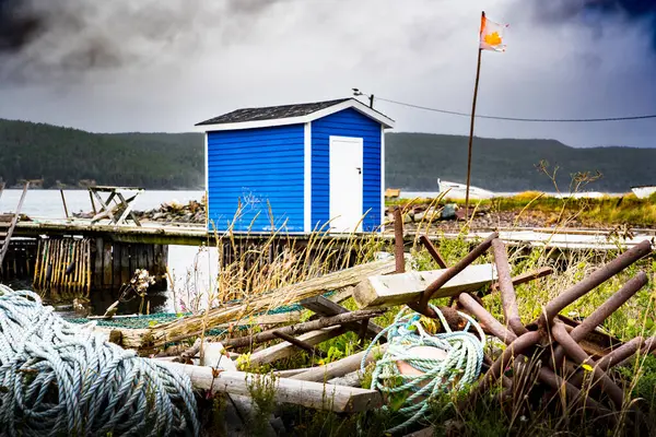 stock image Hearts Content Newfoundland Canada, September 23 2022: Fishing tackle shed painted blue on a wooden dock along the East Coast of Atlantic Canada under stormy skies.