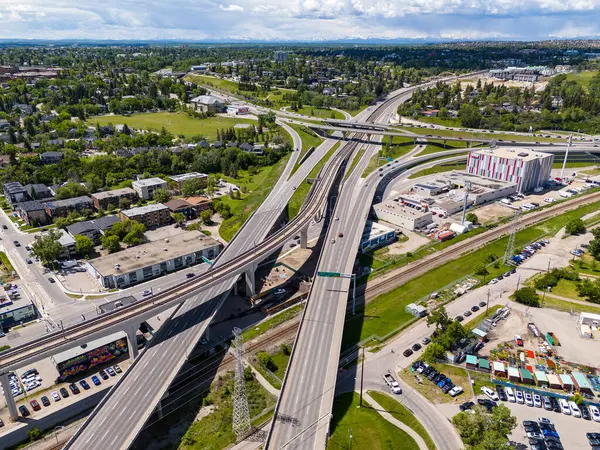 stock image Calgary Alberta Canada, June 20 2024: Aerial looking down view of overpasses and thoroughfare overlooking city streets and distant mountains.