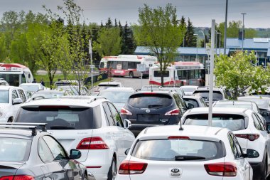 Calgary Alberta Canada, JUne 21 2024: Park ve Ride otoparkı, iş günü Dalhousie İstasyonu 'nda yolcuların otobüs ve demiryolu aktarımı yaptıkları yer.