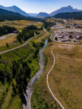 Mountain town scene of the Crowsnest River flowing along a bike path near Coleman Alberta Canada. clipart