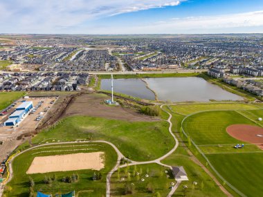 Airdrie Alberta Canada, 25 Mayıs 2024: Büyük patikaları olan ve büyüyen bir topluma tepeden bakan uzak bir fırtına kanalizasyon havuzu görüntüsü.