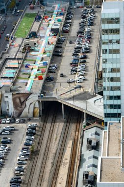 Calgary Alberta Canada, 11 Ekim 2024: Basketbol sahaları ve renkli oyun alanlarıyla dolu şehir merkezindeki patika tünellerini kaplayan eski bir parka inşa edilmiş..