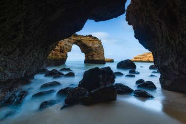 Sahilde, Algarve 'deki mağarada kayalar uzanıyor.