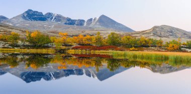 Norveç 'te sonbaharda gölde yansıyan dağlar.