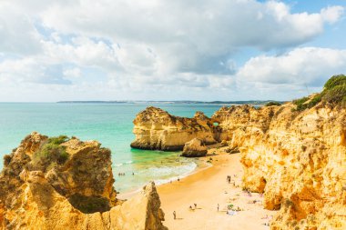 Güneş banyosu yapanlar kumtaşı kayalıkları, Alvor, Agarve, Portekiz, Avrupa 'da kumlu sahillerde dinleniyorlar.
