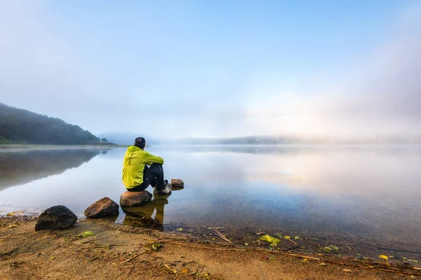 Homem Sentado Lado Lago Nebuloso — Fotografia de Stock