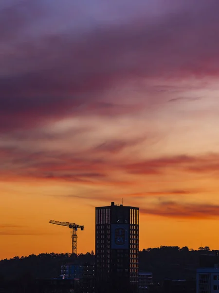 stock image The sun sets to a stunning orange afterglow, casting an ethereal glow on the Gothenburg skyline. Clouds drift lazily in the evening sky above residential architecture.