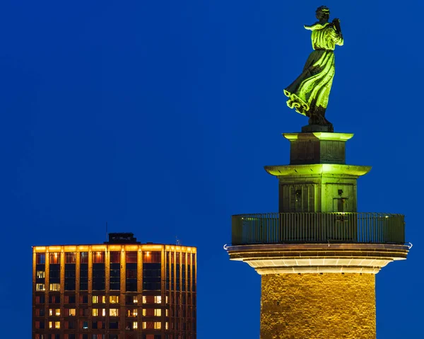Illuminated by night, a bronze statue of a women stands at the Gothenburg waterfront as an iconic tribute for the people at home and for their thoughts and prayers.