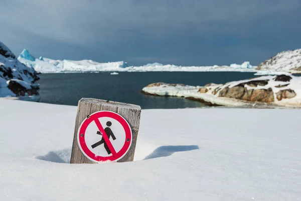 Forbidden to walk sign. Do not walk on the beach. Death or serious injury might occur. Risk of sudden tsunami waves caused by calving icebergs.