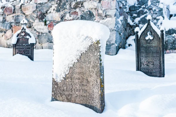 İsveç 'te karla kaplı bir mezarlık, insan yok ve soğuk bir kış mevsimi mezarı donduruyor..