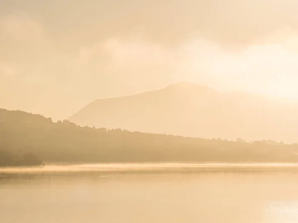 Спокойная Утренняя Сцена Туманного Озера Отражающего Залитые Солнцем Горы Деревья — стоковое фото