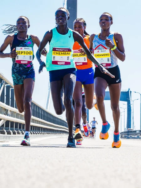 Güneşli bir günde Gteborgsvarvet Half Marathon, Gothenburg, İsveç 'te yarışan enerjik bir grup genç ve yetişkin kadın..